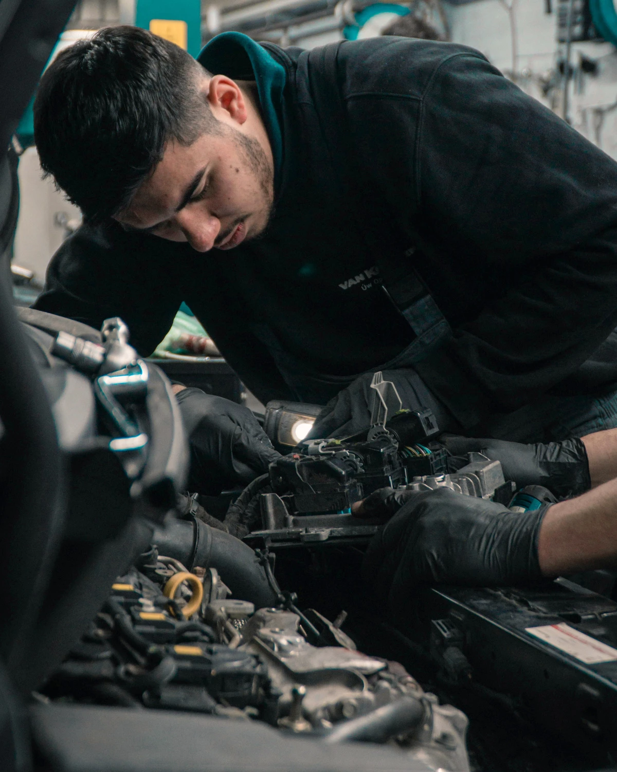 Anzeigenmotiv (Beispiel): Kfz-Mechatroniker arbeitet im Motorraum eines Autos