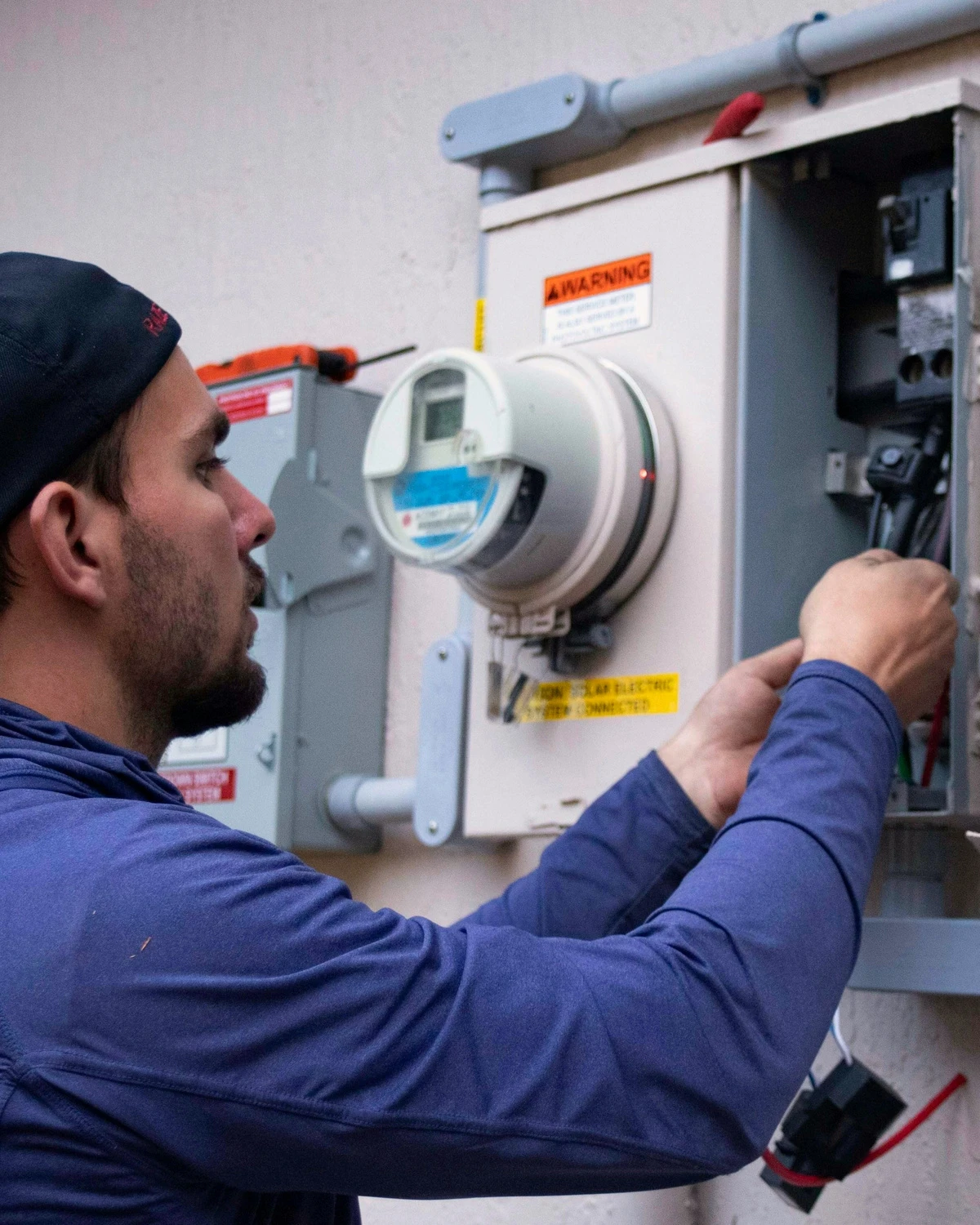 Anzeigenmotiv (Beispiel): Elektroniker arbeitet an einem Zählerschrank