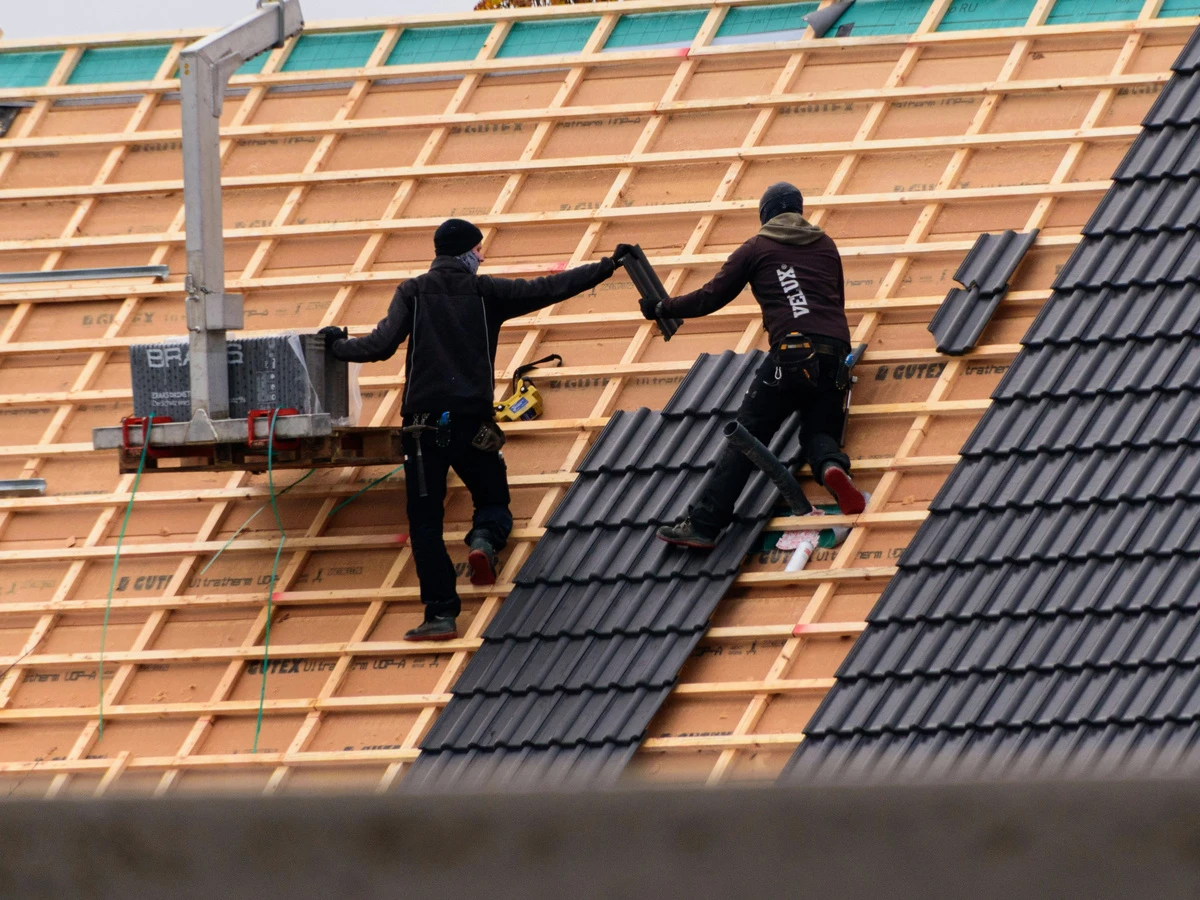 Dachdecker bei der Arbeit auf einem Steildach